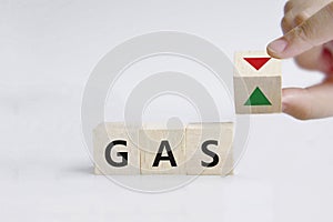 Hand is turning a dice and changes the direction of an arrow symbolizing that the price for gas is changing the trend