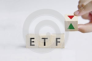 Hand is turning a dice and changes the direction of an arrow symbolizing that the value of an ETF Exchange Traded Fund is goin