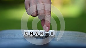 Hand is turning a dice and changes the word change to chance