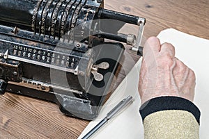Hand turning the handle of adding machine