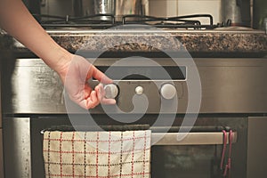 Hand turning knob on stove