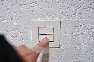 Hand turning off the light on a switch