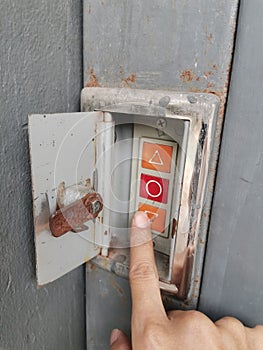 Hand turning off the light switch on the wall of an old building
