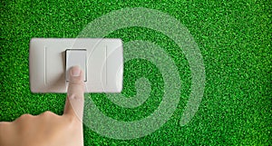 Hand turning off switch with grass background