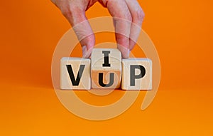 Hand turns a cube and changes the acronym `VUP` - very unimportant person to `VIP` - very important person. Beautiful orange