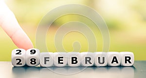 Hand turns dice and changes the date from `February 28` to `February 29` 28 and 29 Februar in German.