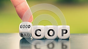 Hand turns a dice and changes the expression `bad cop` to `good cop`, or vice versa.