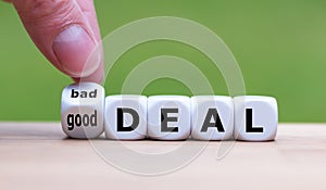 Hand turns a dice and changes the expression `bad deal` to `good deal`. photo