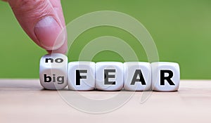 Hand turns a dice and changes the expression `big fear` to `no fear`.