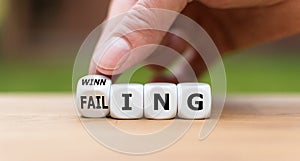 Hand turns a dice and changes the expression `failing` to `winning`