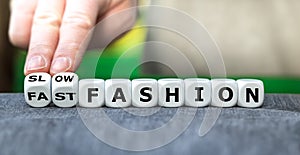 Hand turns dice and changes the expression 'fast fashion' to 'slow fashion.