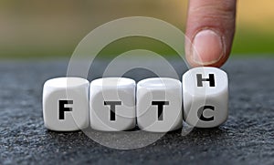 Hand turns dice and changes the expression Fiber to the curb FTTC to Fiber to the home FTTH.