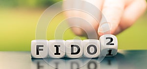 Hand turns a dice and changes the expression `FIDO1` to `FIDO2.