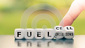 Hand turns a dice and changes the expression `fuel emissions` to `fuel cell.