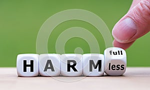 Hand turns a dice and changes the expression `harmfull` to `harmless`.