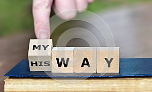 Hand turns dice and changes the expression 'his way' to 'my way'. photo