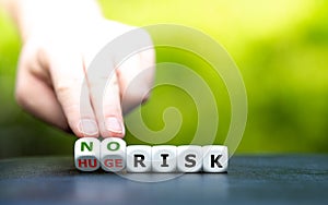 Hand turns dice and changes the expression `huge risk` to `no risk`.