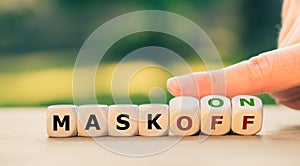 Hand turns dice and changes the expression `mask off` to `mask on`.