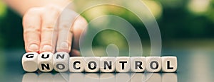 Hand turns dice and changes the expression `no control` to `gun control`.