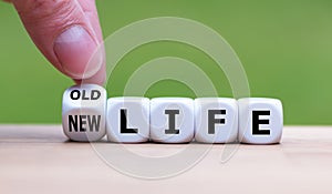 Hand turns a dice and changes the expression `old life` to `new life`