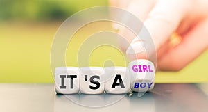 Hand turns a dice and changes the expression `it`s boy` to `it`s a girl`, or vice versa.