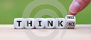 Hand turns a dice and changes the expression `think once` to `think twice`