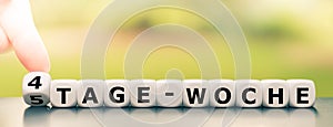 Hand turns a dice and changes the German expression `5 tage woche` `5 day week` in English to `4 tage woche` `4 day wee