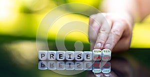 Hand turns dice and changes the German expression `Preise rauf` price up to `Preise runter` price down. photo