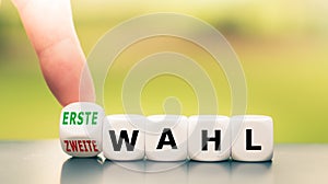 Hand turns a dice and changes the German expression `zweite Wahl` `second choice` in English to `erste Wahl` `first choice` photo