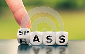 Hand turns a dice and changes the German word `Hass` `hate` in English to `Spass` `fun` in English, or vice versa.
