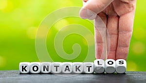 Hand turns dice and changes the German word `Kontakt` contact to `kontaktlos` contactless.