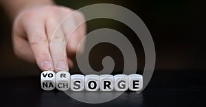 Hand turns dice and changes the German word `Nachsorge` aftercare to `Vorsorge` precaution9: