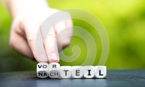 Hand turns dice and changes the German word `Nachteil` disadvantage to `Vorteil` advantage.