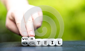 Hand turns dice and changes the German word `Nachteil` disadvantage to `Vorteil` advantage.
