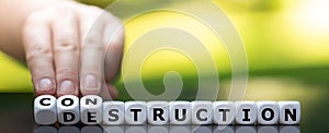Hand turns dice and changes the word destruction to construction