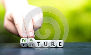 Hand turns dice and changes the word `future` to `nature`.