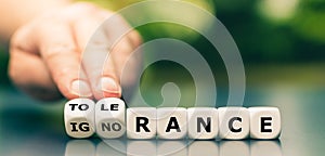 Hand turns dice and changes the word ignorance to tolerance