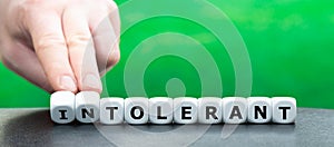 Hand turns dice and changes the word `intolerant` to `tolerant`.