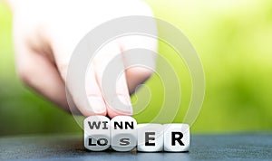 Hand turns dice and changes the word loser to winner.