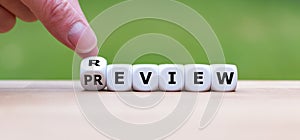 Hand turns a dice and changes the word `review` to `preview`. photo