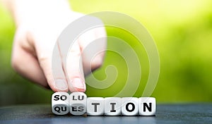 Hand turns dice and changes the word question to solution