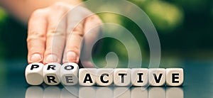 Hand turns dice and changes the word reactive to proactive