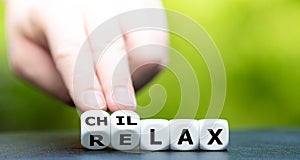 Hand turns dice and changes the word `relax` to `chillax`.