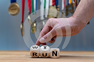 Hand turns a dice and changes the word `RUN` to `WIN`