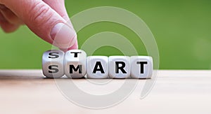 Hand turns dice and changes the word `start` to `smart`.