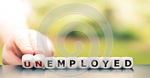 Hand turns a dice and changes the word `unemployed` to `employed`.