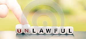 Hand turns dice and changes the word `unlawful` to `lawful`.