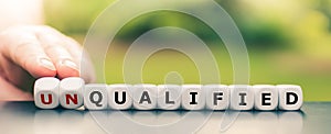 Hand turns dice and changes the word unqualified to qualified photo