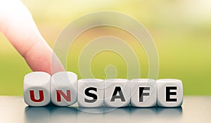 Hand turns dice and changes the word unsafe to safe