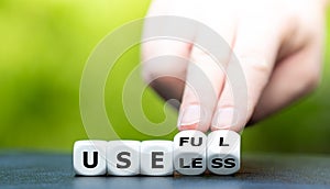 Hand turns dice and changes the word `useless` to `useful`.